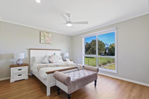 a white bedroom with a bed and a window at Sunseeker on Tambo in Metung