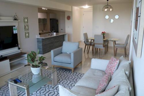 a living room with a couch and a dining room at 16H Luxury Oceanview Playa Bonita Resort Panama in ArraijÃ¡n