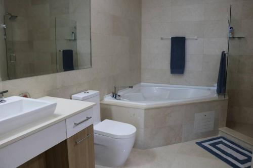 a bathroom with a tub and a toilet and a sink at 15B Stunning Oceanfront Views Panama Resort Life in ArraijÃ¡n
