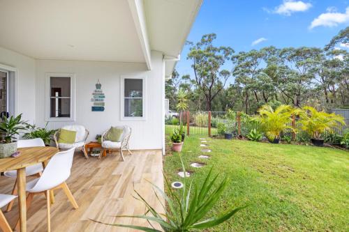 a living area with a table and chairs and a yard at Break Away in Burrill Lake