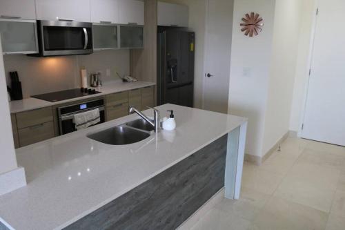 a kitchen with a sink and a counter top at 16H Luxury Oceanview Playa Bonita Resort Panama in ArraijÃ¡n