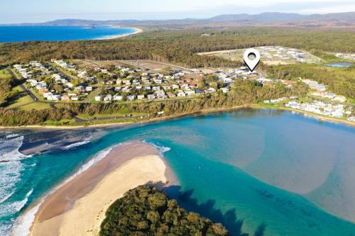 an airship flying over a beach next to the ocean at Break Away in Burrill Lake
