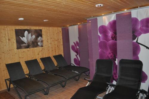 a row of chairs in a waiting room with flowers on the wall at Mathiasl Panorama Ferienwohnungen in Bodensdorf