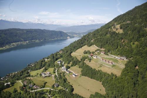 an aerial view of a river and a village at Mathiasl Panorama Ferienwohnungen in Bodensdorf