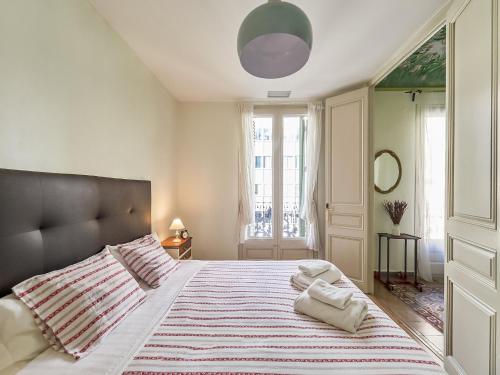 a bedroom with a large bed with a striped blanket at Belvilla by OYO Rambla Paris Apartment in Barcelona
