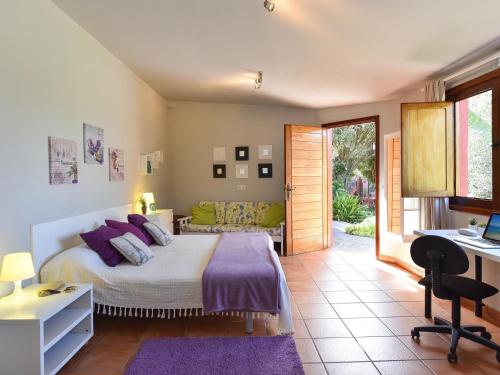 a bedroom with a bed with purple pillows and a desk at beautiful 5 bedroom property with sea view, private tennis court private pool in Arucas