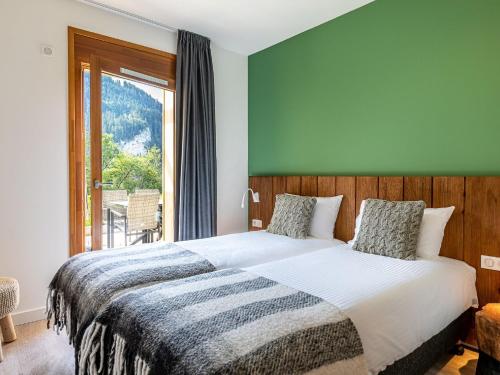 a bedroom with a large bed and a large window at Sunny Terrace & Ski Access in Abondance