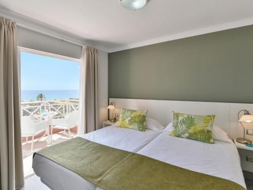 a bedroom with a bed with a view of the ocean at Fantastic holiday home in Playa del Ingles a few meters from the beach in Playa del Ingles