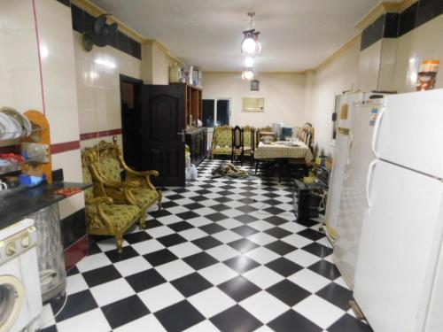- une cuisine avec un sol en damier noir et blanc dans l'établissement فيلا للايجار مفروش بمدينة العبور, à ‘Ezbet el-Insha