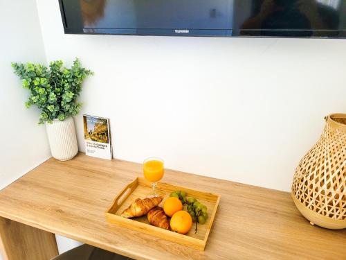 un plateau de fruits et un verre de jus d'orange sur une table dans l'établissement Appartement double climatisé - Proche Tram & Centre, à Montpellier