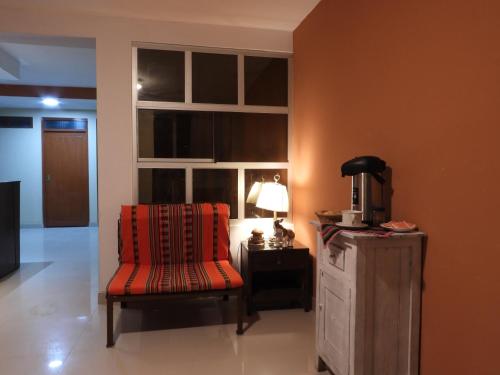 une chambre avec une chaise, une table et une fenêtre dans l'établissement Kuelap Guest House, à Chachapoyas