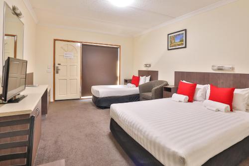 a hotel room with two beds and a flat screen tv at Boulevard Motor Inn in Mildura