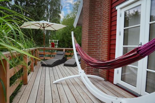 a hammock and an umbrella on a deck at Sjö Hus in KÃ¶hn