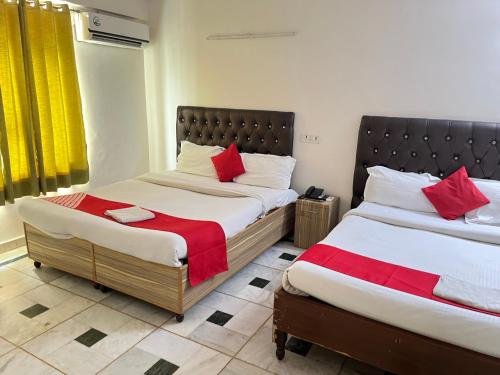 1 dormitorio con 2 camas y almohadas rojas en Hotel Star Palace - Near Karol Bagh Metro, en Nueva Delhi