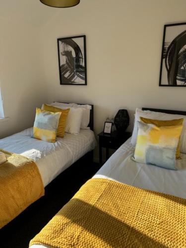 een slaapkamer met 2 bedden met gele en witte kussens bij 4 BR House, Kingsize Beds, Free Parking in Farnham Royal