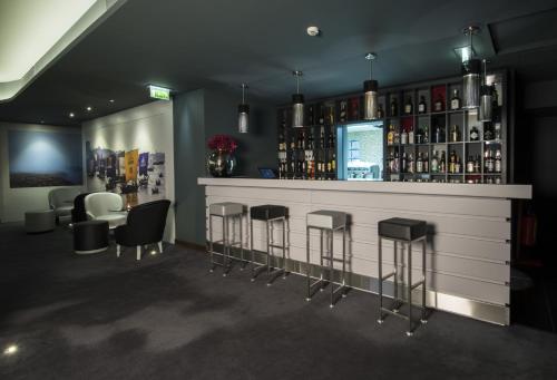 a bar with bar stools and bottles of alcohol at Vila Gale Collection Douro in Lamego
