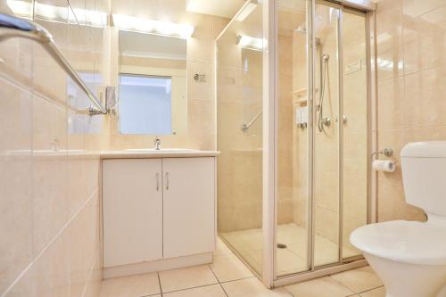 a bathroom with a shower and a toilet and a sink at Boulevard Motor Inn in Mildura