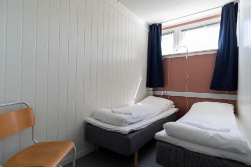 una piccola camera con due letti e una finestra di Reine Basecamp - Apartments & Rooms a Reine