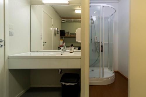 bagno con lavandino e doccia di Reine Basecamp - Apartments & Rooms a Reine