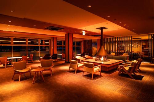 a lobby with chairs and a table and a couch at Ooedo Onsen Monogatari Premium Kinosaki in Toyooka
