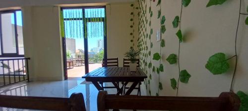 ein Esszimmer mit einem Tisch und einem Balkon in der Unterkunft Nhật Lệ Oyster House in Dong Hoi