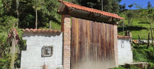 Bolívar的住宿－LA RIVIERA Posada Campestre，一座带木门的小砖砌建筑