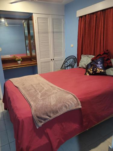K&S Apartment في سيغاتوكا: غرفة نوم بسرير وبطانية حمراء