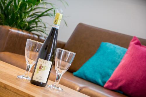 a bottle of wine sitting on a table with two glasses at The Lion Gate Mews in Kingston upon Thames