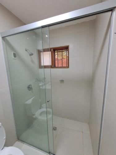 a glass shower in a bathroom with a toilet at Sur Backpackers in Santa Cruz de la Sierra