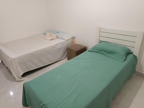2 camas en una habitación con edredón verde en Apartamento - Diária ou Curta Temporada 34, en Salvador