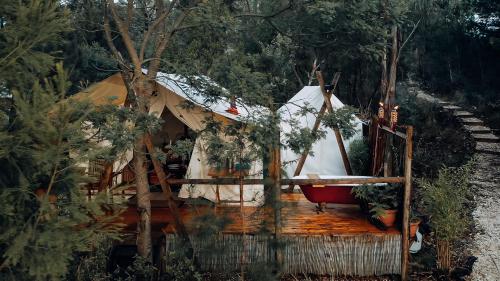 a yurt with a red tub in the woods at Wingtons Glamping in Clarence Point
