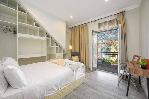 a bedroom with a bed and a desk and a window at Cozy 3 bedroom terrace in CBD in Sydney