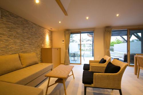 a living room with a couch and two chairs at Mezzo ALL SUITE VILLAS in Miyazu