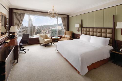 a bedroom with a large white bed and a desk at Island Shangri-La, Hong Kong in Hong Kong