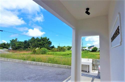a view from the outside of a house with a window at Hichu House ハイチューハウス in Nago
