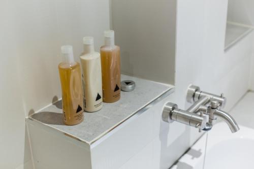 four bottles sitting on a shelf in a bathroom at Phimai Paradise Boutique Hotel in Nakhon Ratchasima