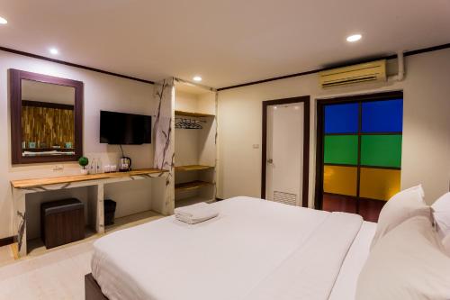 a bedroom with a large white bed and a desk at Phimai Paradise Boutique Hotel in Nakhon Ratchasima