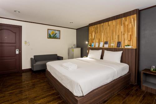 a bedroom with a large bed and a chair at Phimai Paradise Boutique Hotel in Nakhon Ratchasima