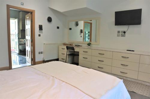 a bedroom with a bed and a desk and a television at rooms close to central london in London