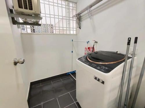 eine kleine Küche mit Waschmaschine in einem Zimmer in der Unterkunft Kulai d putra suites beside ioiMall near JPO and Airport in Kulai
