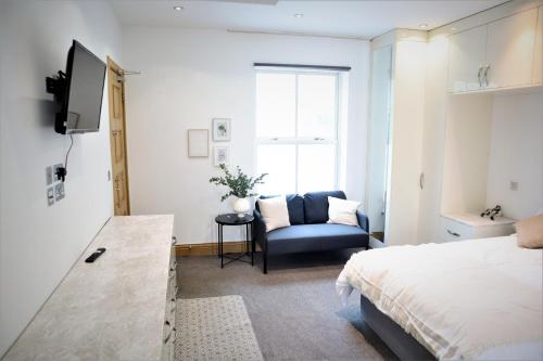 een slaapkamer met een bed, een stoel en een raam bij Camden, London, Holloway Rooms in Londen