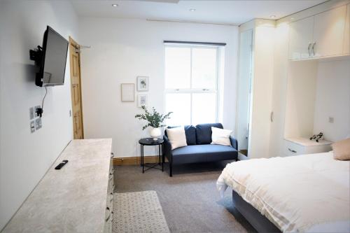 a bedroom with a bed and a chair and a window at rooms close to central london in London