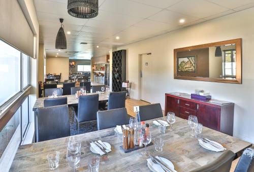 a dining room with a long table and chairs at Boulevard Motor Inn in Mildura