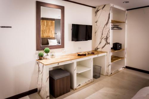 a room with a desk and a mirror at Phimai Paradise Boutique Hotel in Nakhon Ratchasima