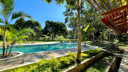 a swimming pool in a park with palm trees at Villa Sebastiana Bungalows in Tarapoto