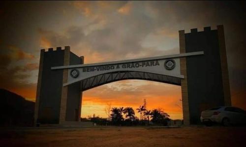 a building with an arch with the sunset in the background at Pousada Vino & Leta O seu parador no centro in Grão Pará