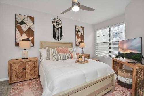 a bedroom with a large white bed and a tv at The Bohemian Escape near Rice Village in Houston! in Houston