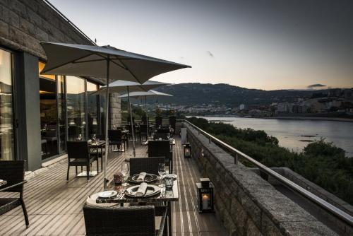 a balcony of a restaurant with tables and an umbrella at Vila Gale Collection Douro in Lamego