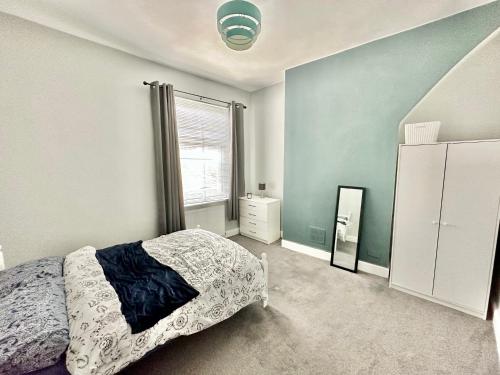 een slaapkamer met een bed en een raam bij New Brighton Beach in Wallasey