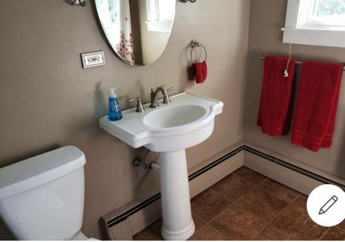 a bathroom with a white sink and a mirror at Cummings Place AirBNB in Wellsville